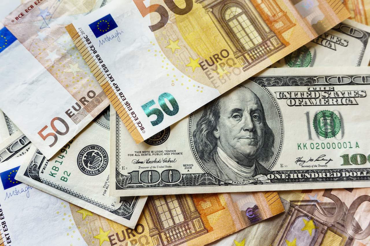 Euroscheine, die auf der Dollar-Note liegen.