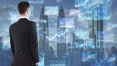 Stock market and investing concept with businessman back view looking at digital screens with financial chart diagrams, arrows and graphs on city skyscrapers background