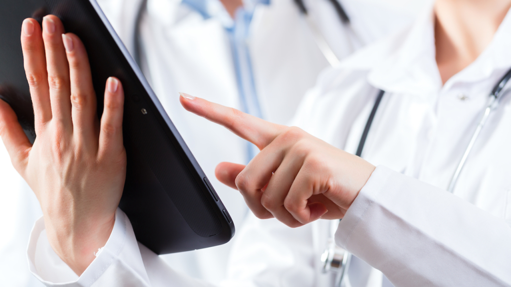 Junges Ärzte Team in einer Praxis mit Tablet in der Hand