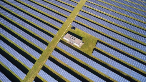 Schnurgerade Reihen von Kollektoren eines Solarparks aus der Luft