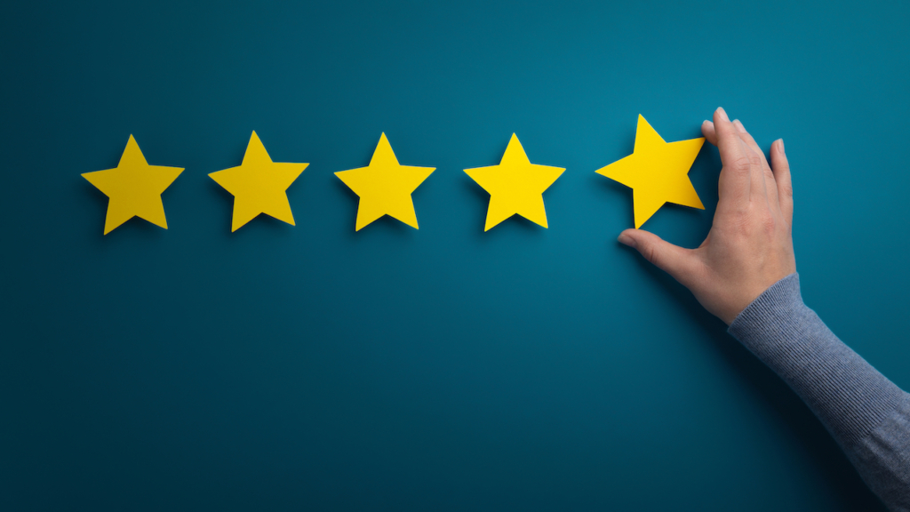 Geschäftsfrau zeigt fünf Sterne, um das Rating zu erhöhen