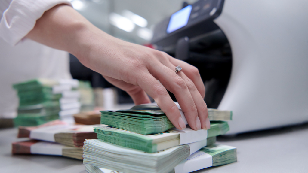 Bankangestellte sortieren und zählen Papierbanknoten