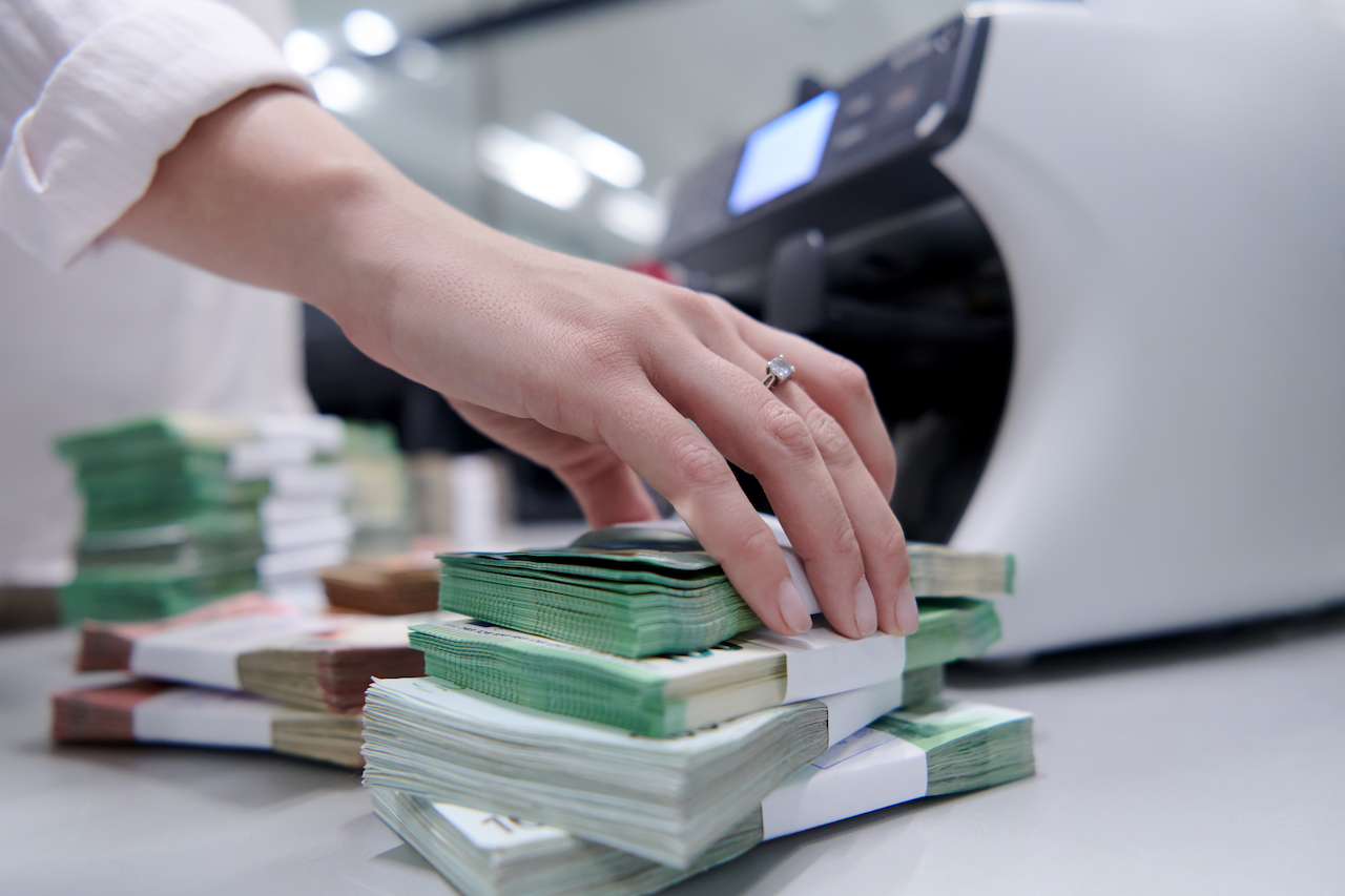 Bankangestellte sortieren und zählen Papierbanknoten