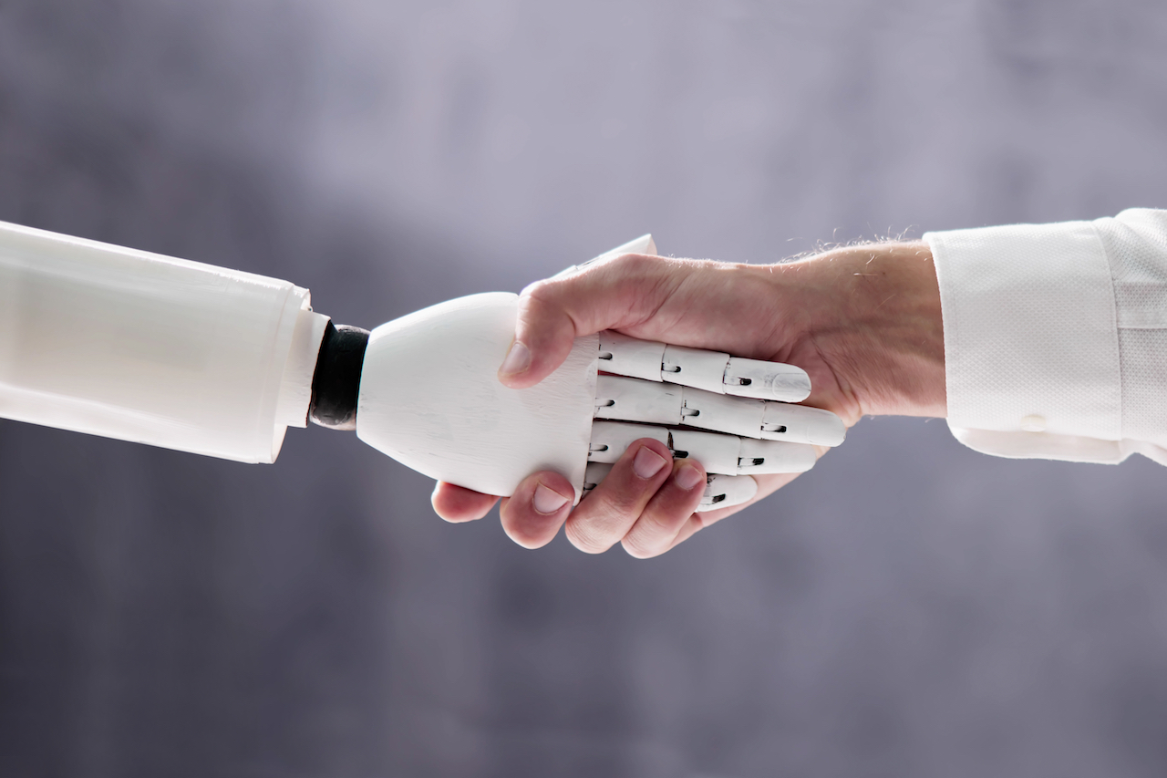 KI-Roboter Hand schüttelt menschliche Hand