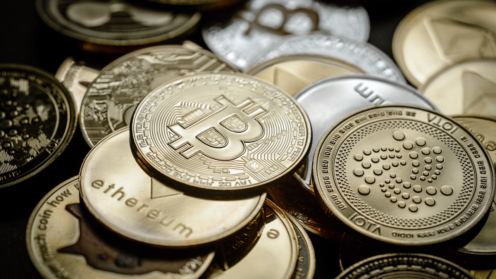 Haufen von Münzen mit Symbolen von Krypto-Währungen