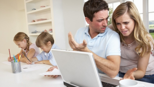 Eltern bei der Steuererklaerung, Kinder im Hintergrund