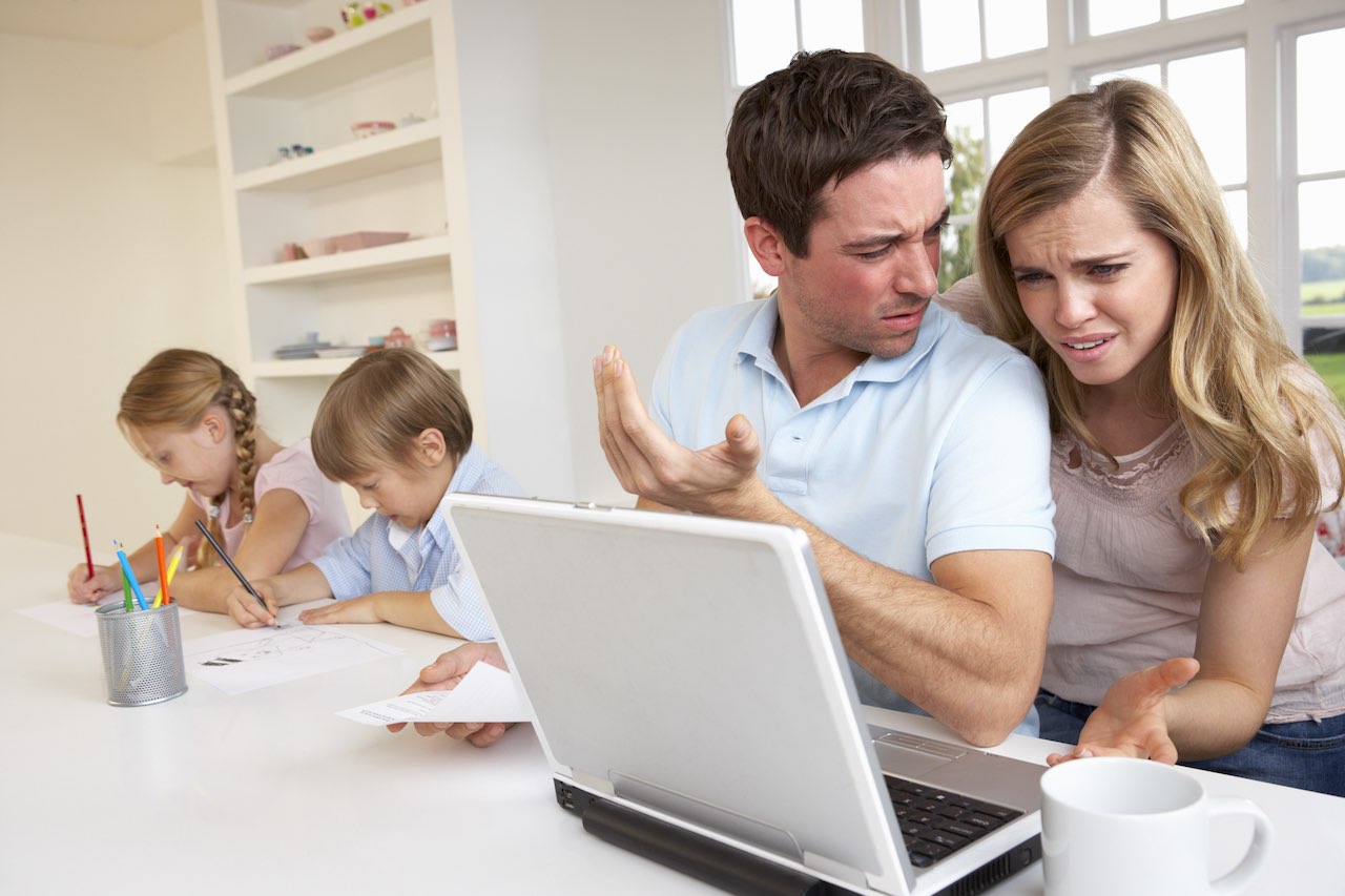 Eltern bei der Steuererklaerung, Kinder im Hintergrund