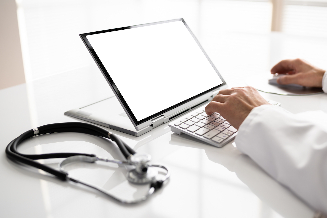 Mittelteil des Arztes mit Laptop am Schreibtisch