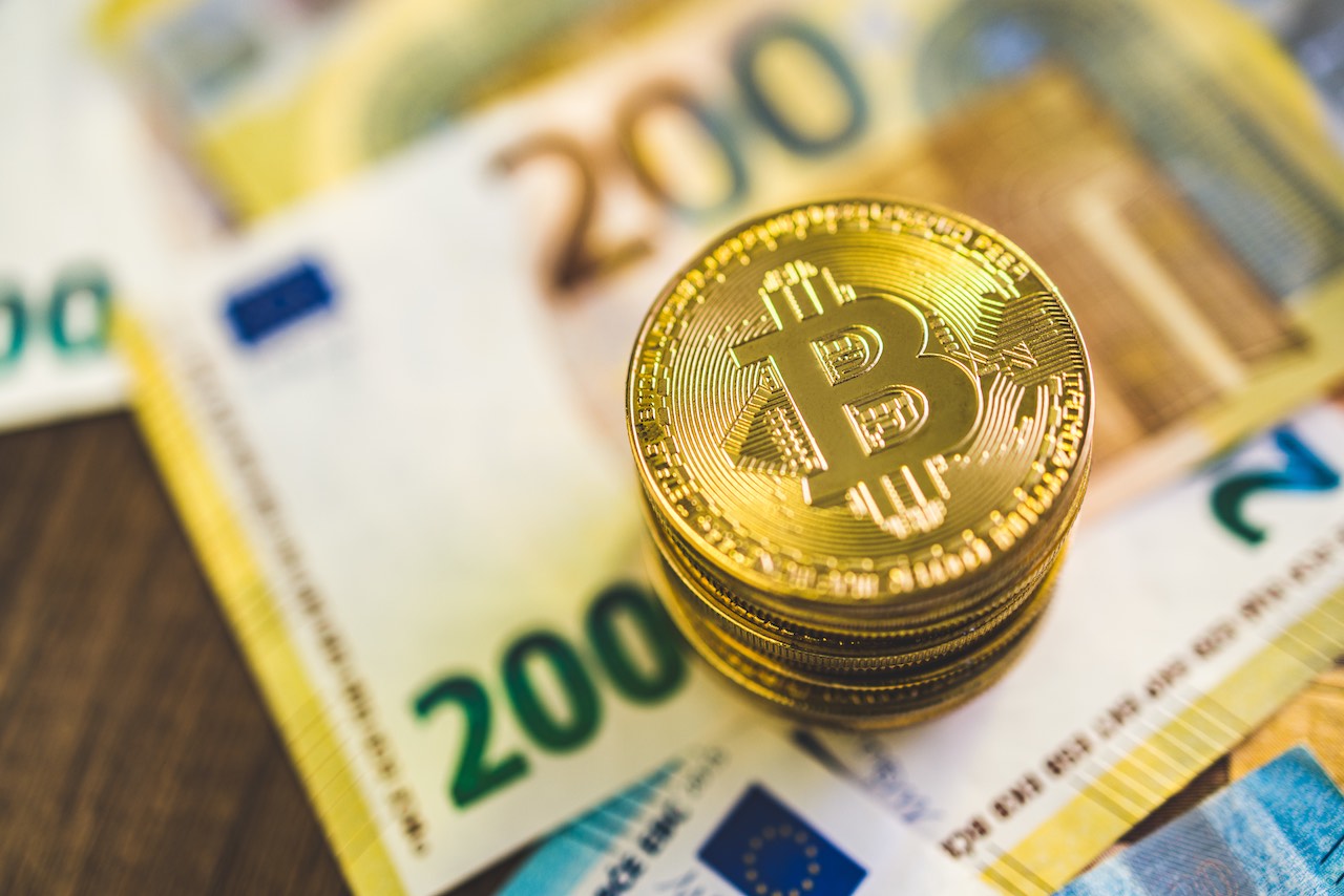 Bitcoin-Muenzen auf Euro-Scheinen