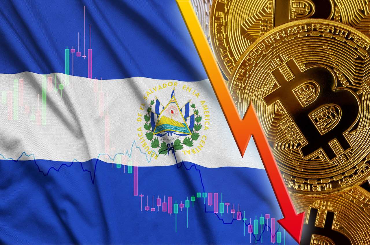 Bitcoin mit stark fallendem Kurspfeil vor der Flagge von El Salvador
