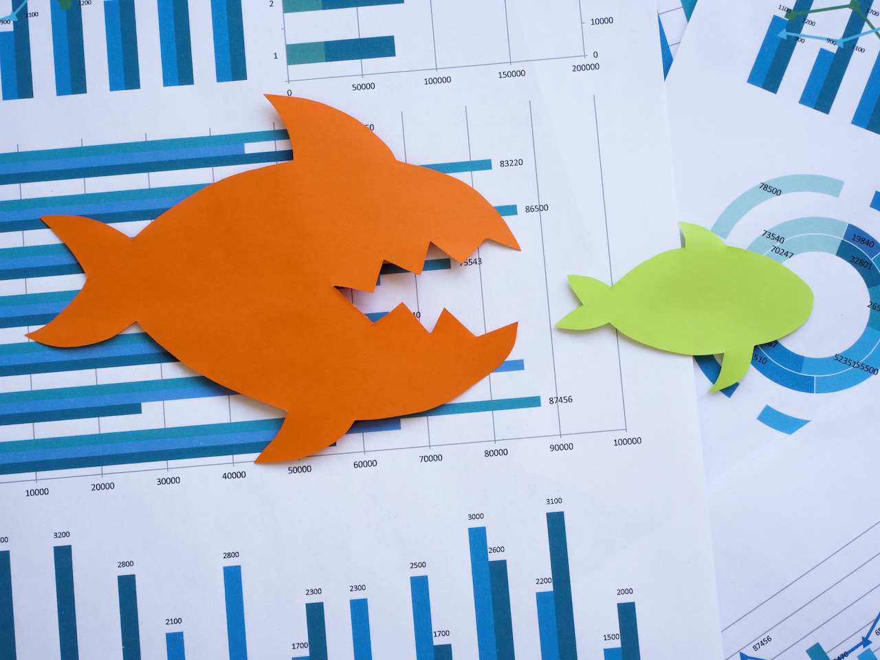 Mergers and acquisitions concept. Two paper fish lie on