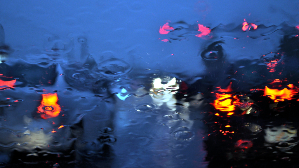 Rainy car windshield with shallow depth of field.