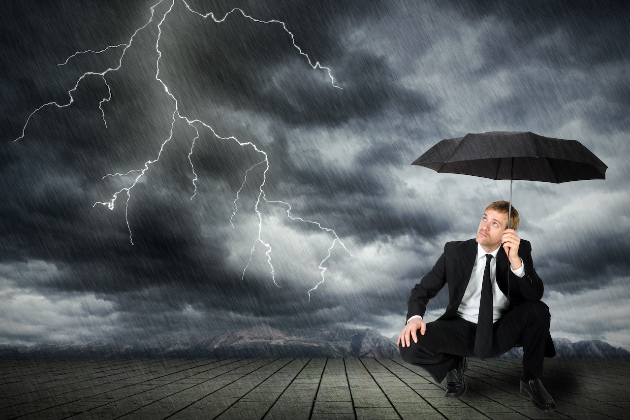 Mann im Anzug und Regenschirm sucht Schutz vor Unwetter