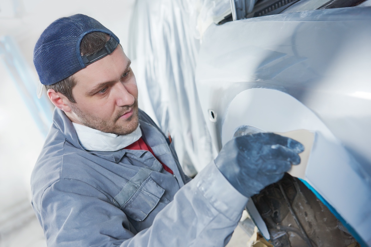 Autoreparator verputzt Karosseriehaube