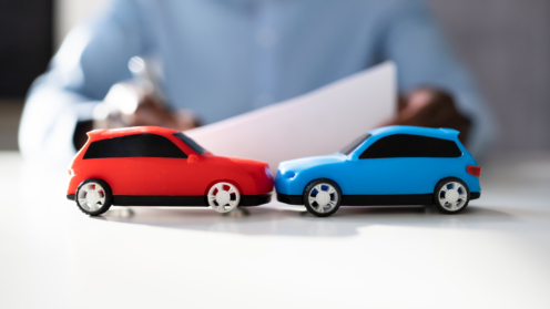 Ein rotes und ein blaues Spielzeugauto prallen aufeinander