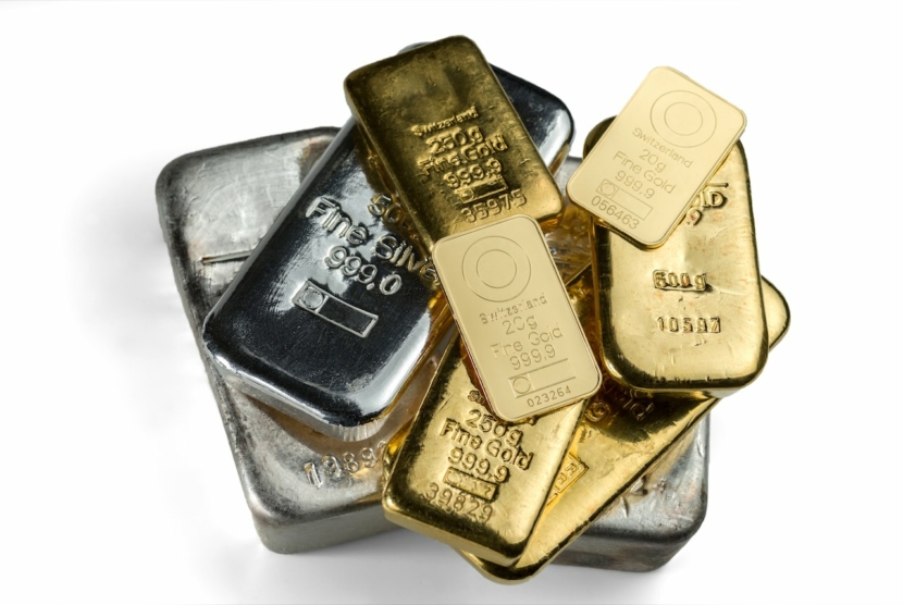 mehrere gegossene und geprägte Goldbarren und Silberbarren isoliert auf weißem Hintergrund. Selektiver Fokus.