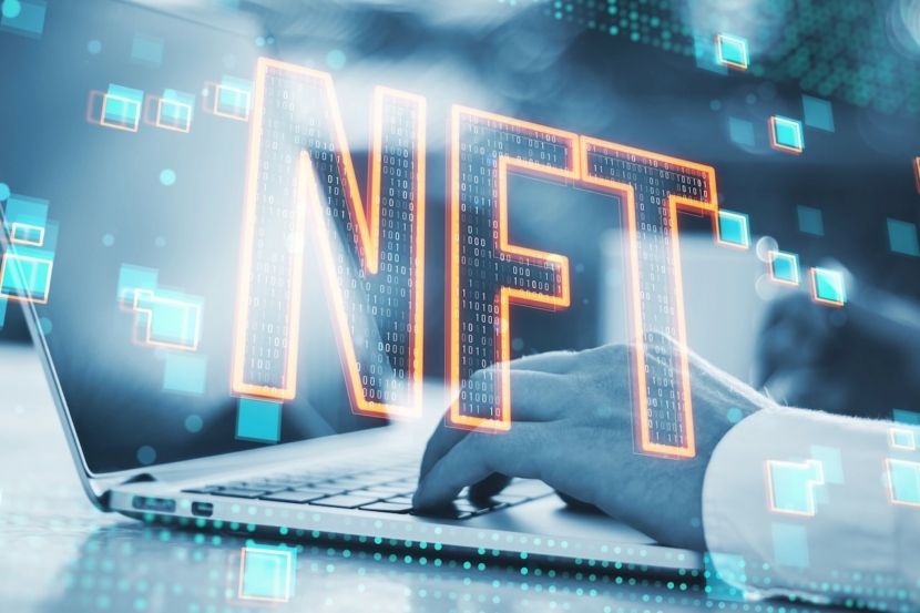 Ein beeindruckendes Bild, das "NFT" -Text in einem digitalen 3D-Stil zeigt, der über einem Laptop mit Neonbeleuchtung und technischem Ambiente schwebt
