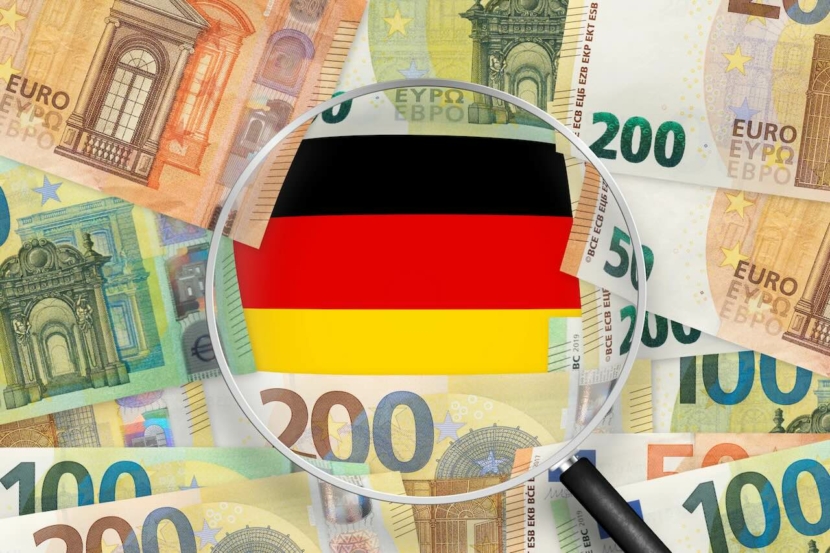 Euroscheine mit Blick auf die Deutschland-Flagge durch die Lupe. Der Euro ist die offizielle Währung der Europäischen Union