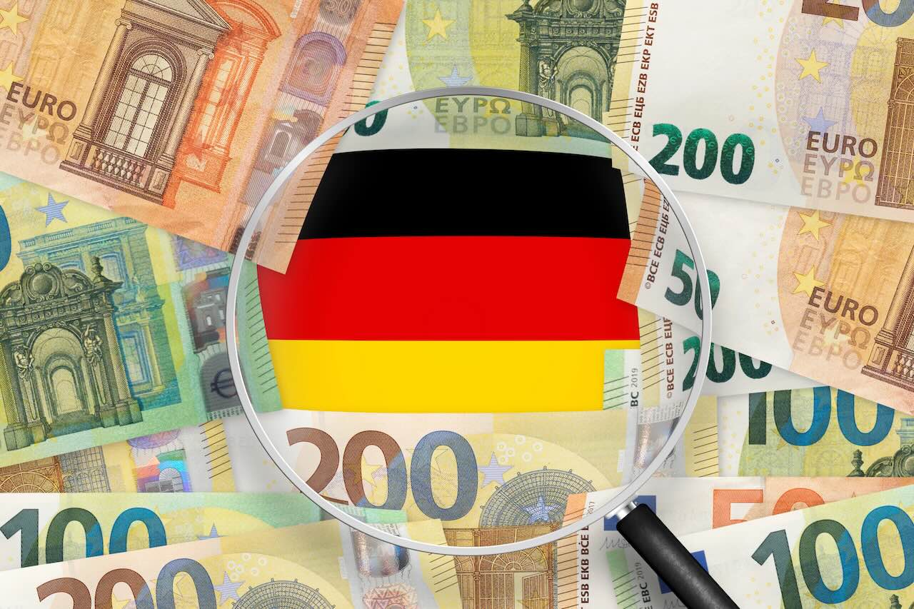 Euroscheine mit Blick auf die Deutschland-Flagge durch die Lupe. Der Euro ist die offizielle Währung der Europäischen Union