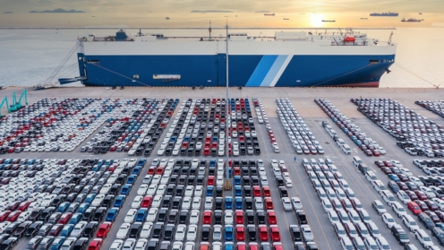 Luftbild-Fahrzeugträgerschiff,das Auto für den weltweiten Versand belädt,Großer RoRo-Fahrzeugtransporter (Roll on / off),Neuwagen im Hafen für den Importexport in die ganze Welt aufgereiht.