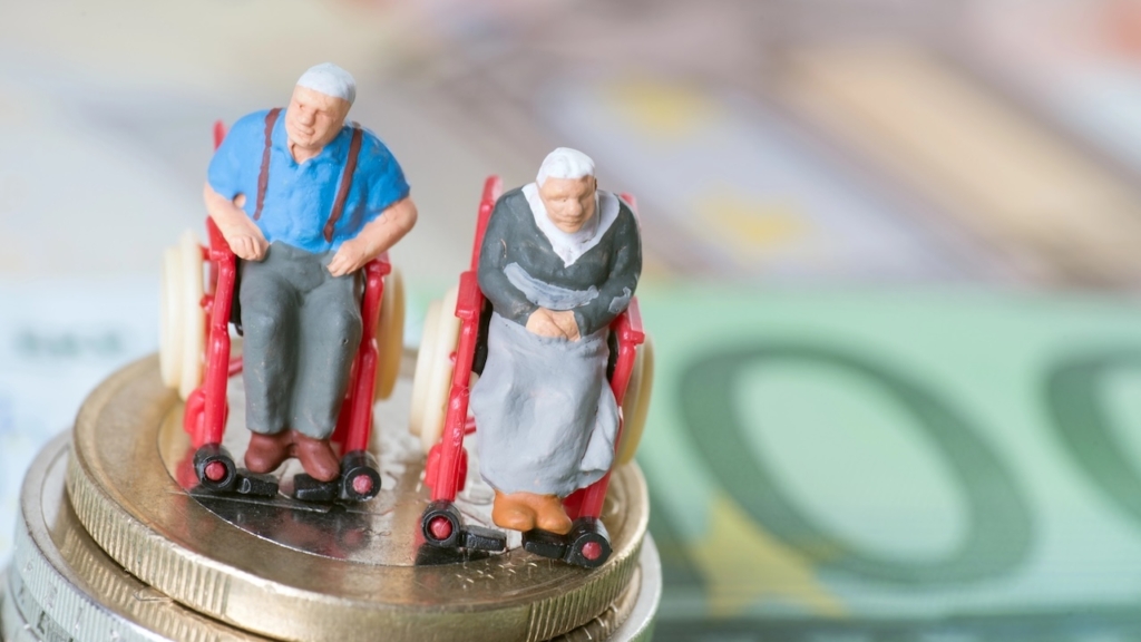 Altes Ehepaar im Rollstuhl, auf Euroscheinen. Altersarmut, Pflegebedürftigkeit, Sorgen