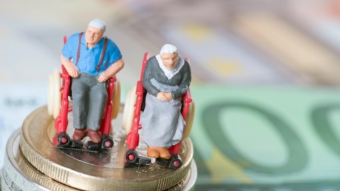 Altes Ehepaar im Rollstuhl, auf Euroscheinen. Altersarmut, Pflegebedürftigkeit, Sorgen