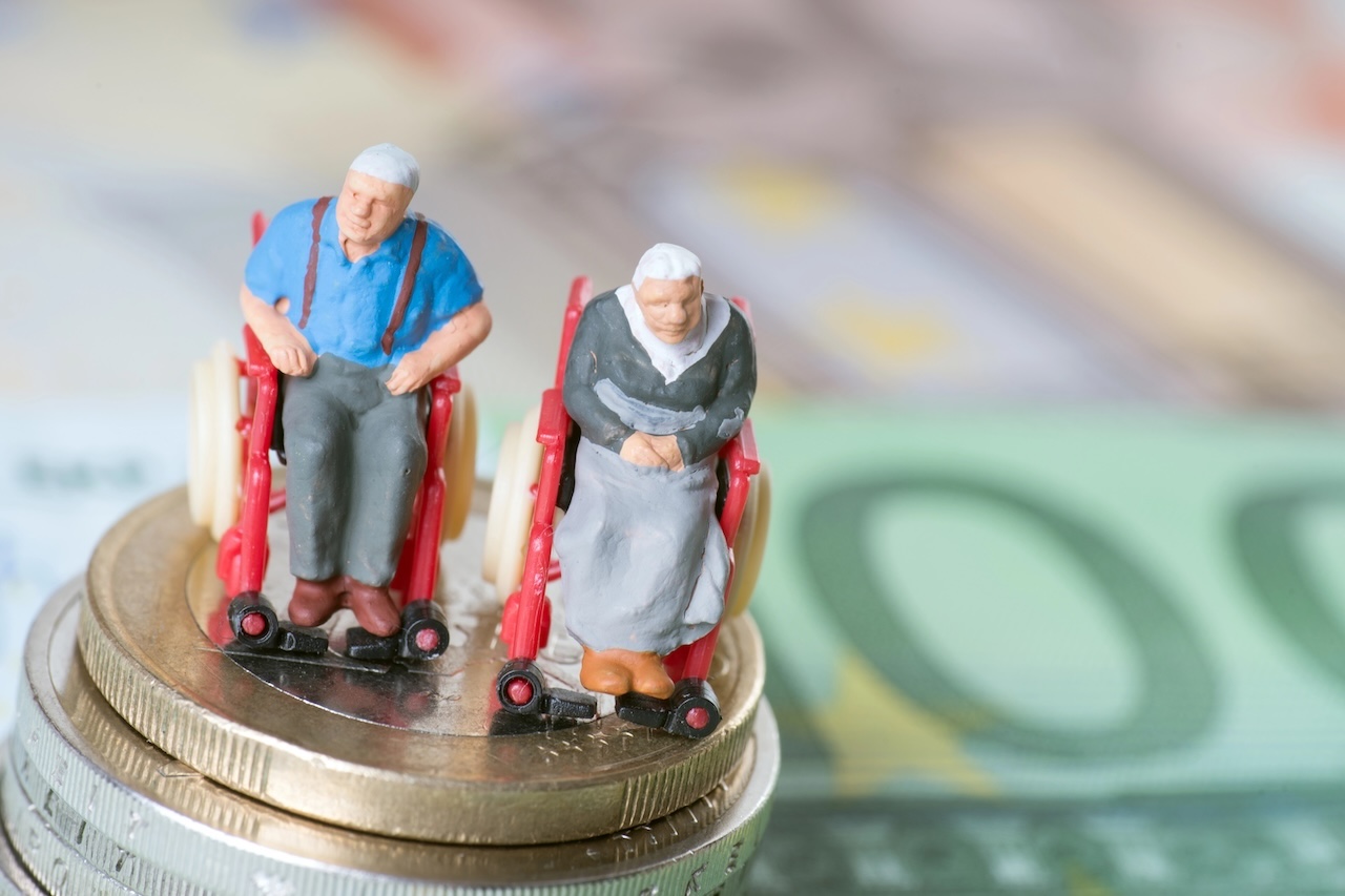 Altes Ehepaar im Rollstuhl, auf Euroscheinen. Altersarmut, Pflegebedürftigkeit, Sorgen