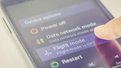 Nahaufnahme des Fingers, der die Flugmodus-Taste auf dem Smartphone drückt