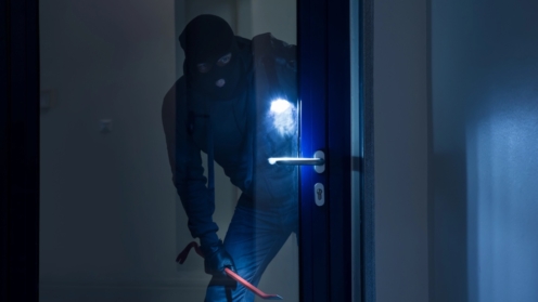 Einbruch bei Nacht, Einbrecher vor einer Glastür, Hausratversicherung, Versicherung