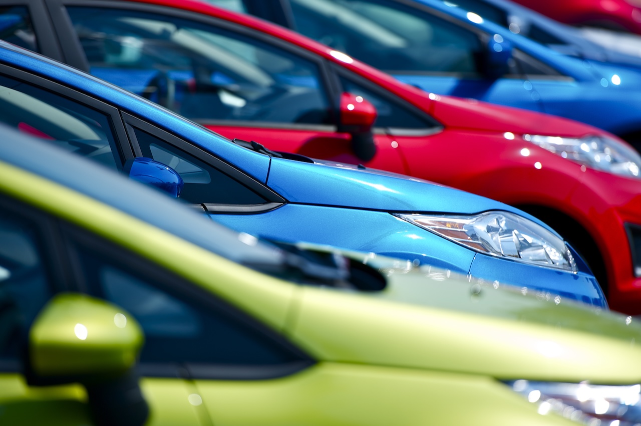Bunte Autos auf Lager. Kleine europäische Fahrzeuge auf Lager. Viele Farben zur Auswahl. Autos auf Lager beim Händler. Fotosammlung zum Thema Transport