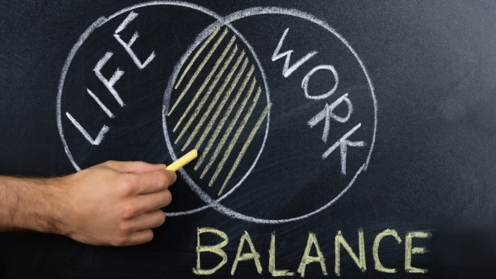 Nahaufnahme einer Hand, die das Konzept der Work-Life-Balance auf einer Tafel zeigt
