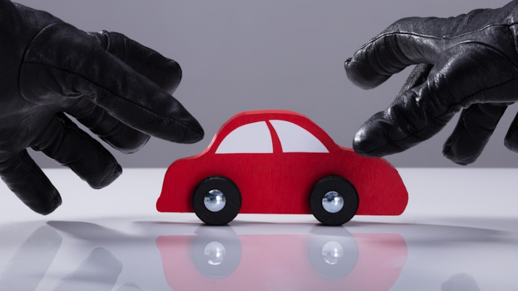 Autodiebstahl, Kfz, Nahaufnahme der Hand eines Diebes, der Handschuhe trägt und ein rotes Auto stiehlt