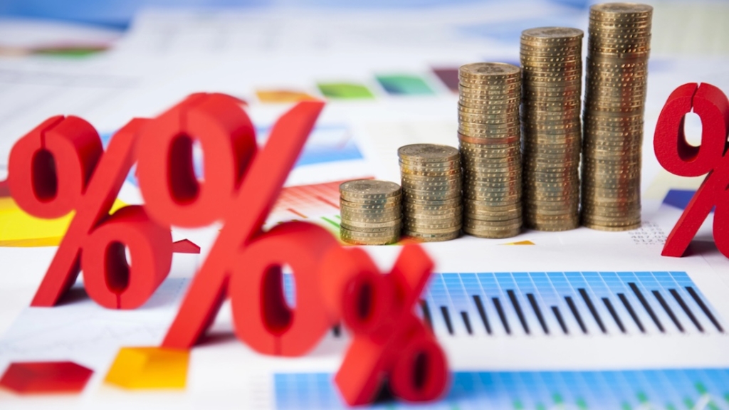 Finanzkonzept. Grafik aus Münzstapeln mit roten Prozentzeichen auf Berichten.