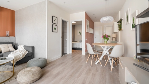 Comfortable seating area with a terracotta color wall with a sofa and poufs near the dining area in the living room studio. Concept of a modern European interior.