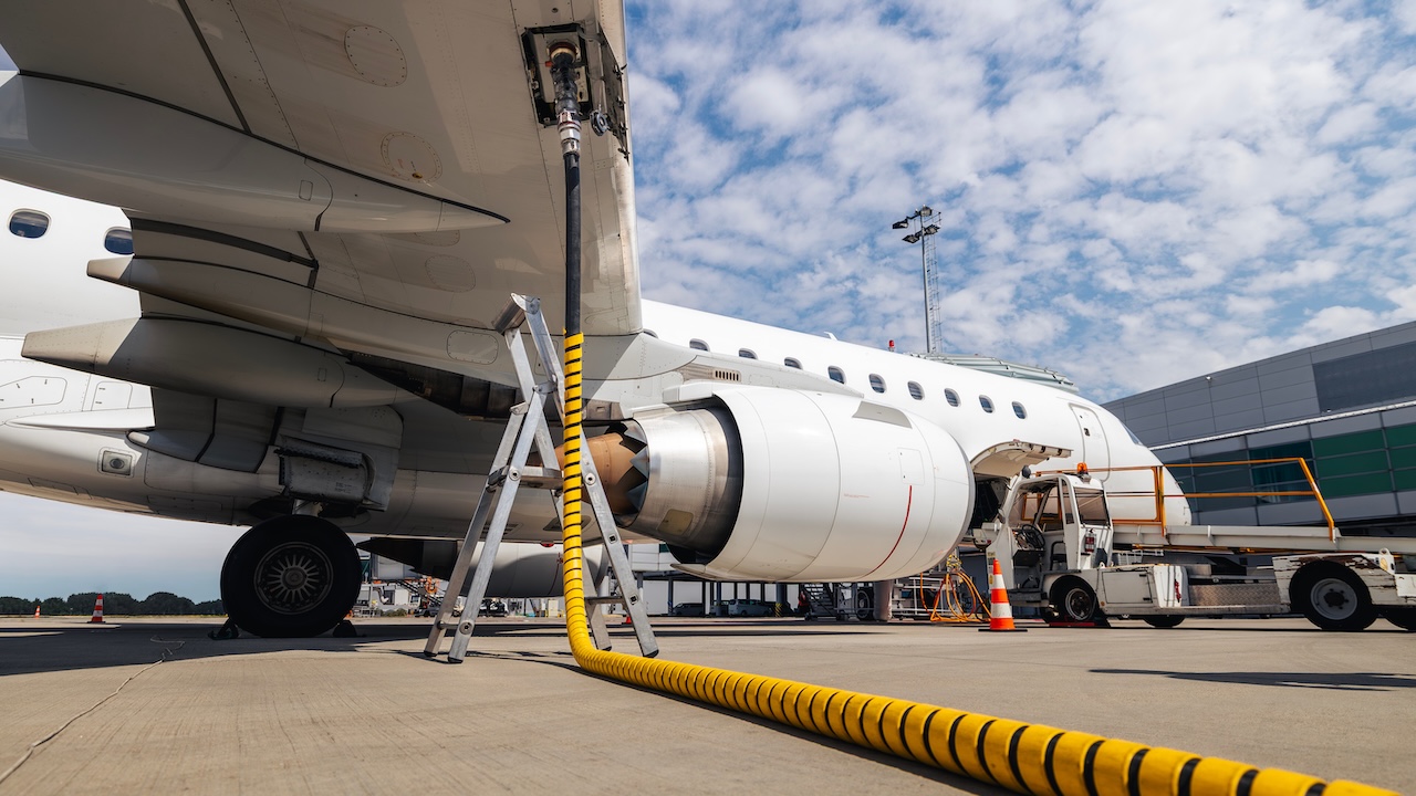 Ein Flugzeug wird mit einem Schlauch betankt.