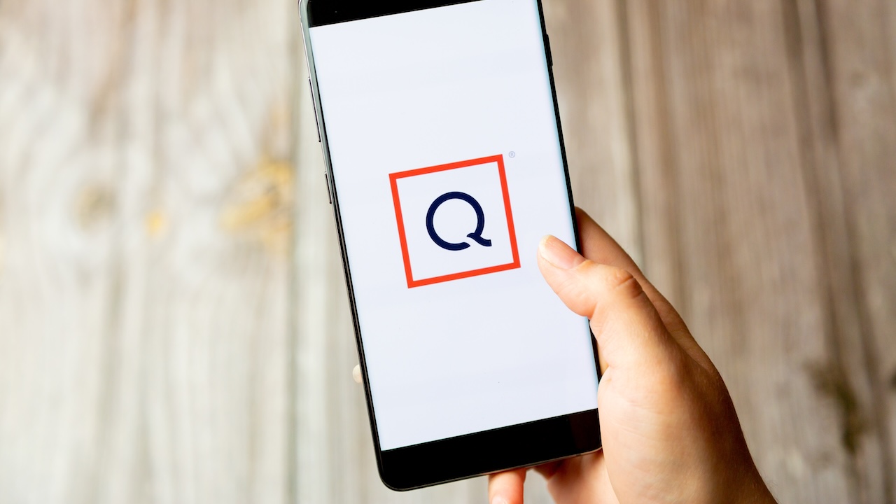 Smartphone in der Hand mit QVC-Logo auf dem Display