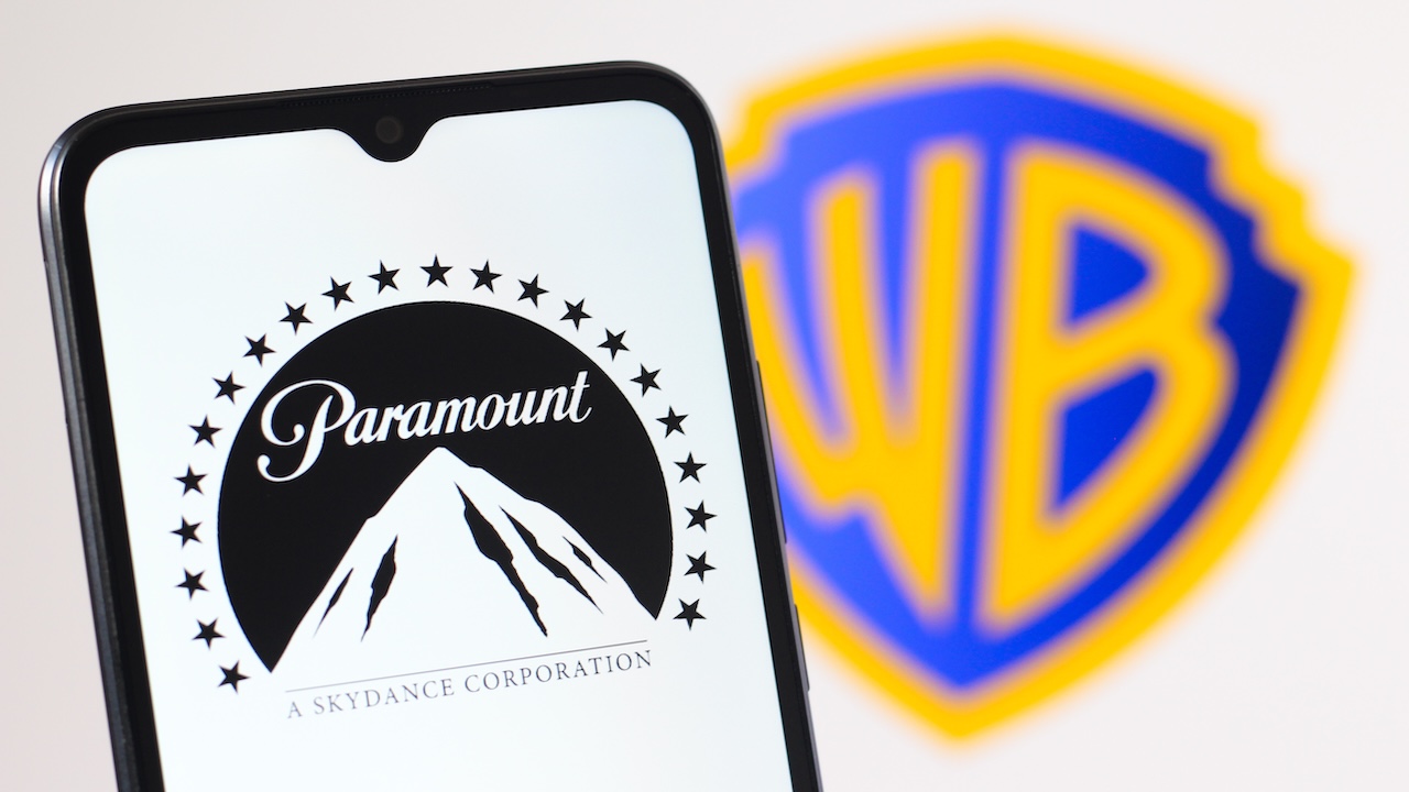 Smarthone mit Paramount-Logo auf dem Display vor dem Hintergrund eines Warner Bros.-Logo