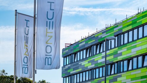 Corporate flags BioNTech headquarters, leader mRNA vaccine development, German biotechnology company