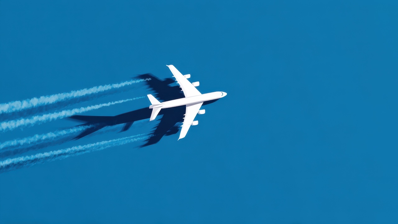 Flugzeug von oben über einem azurblauen Himmel.