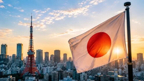 Japanische Flagge vor der Skyline von Tokio mit dem Tokyo Tower im Hintergrund.