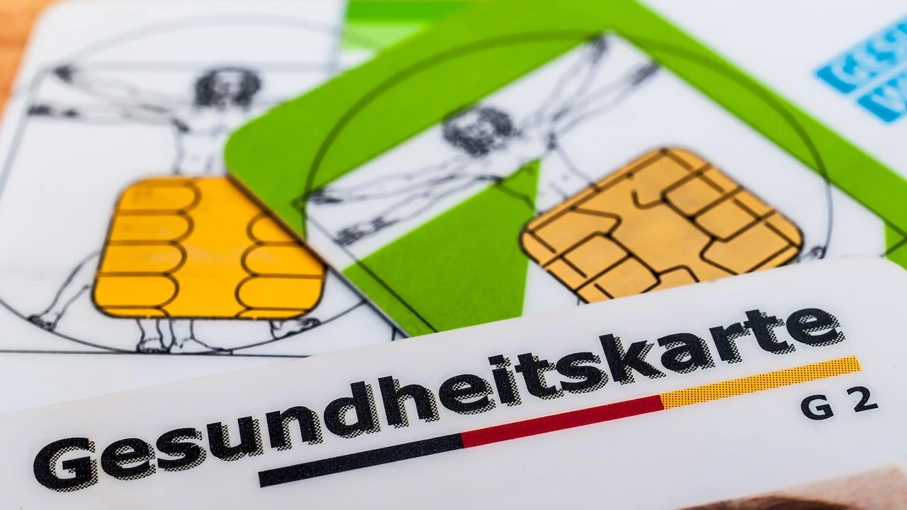Mehrere Gesundheitskarten liegen auf einem Tisch.
