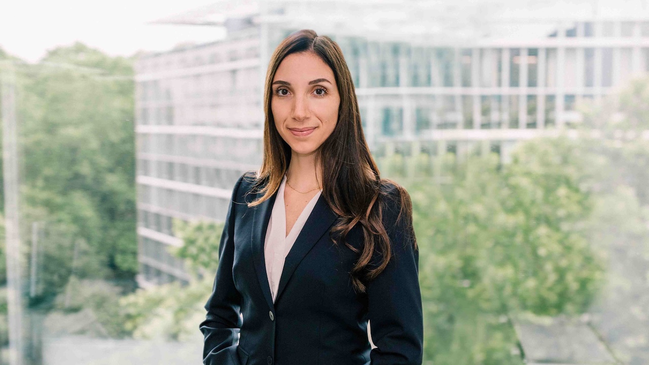Maria Angela Ciriello vor dem Hintergrund eines Bürohauses und Bäumen.