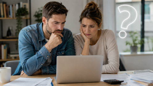 Ein junges Elternpaar sitzt nachdenklich vor einem Laptop, während ein eingeblendetes Fragezeichen ihre Unsicherheit über die neuen Kindergeld-Regelungen symbolisiert.