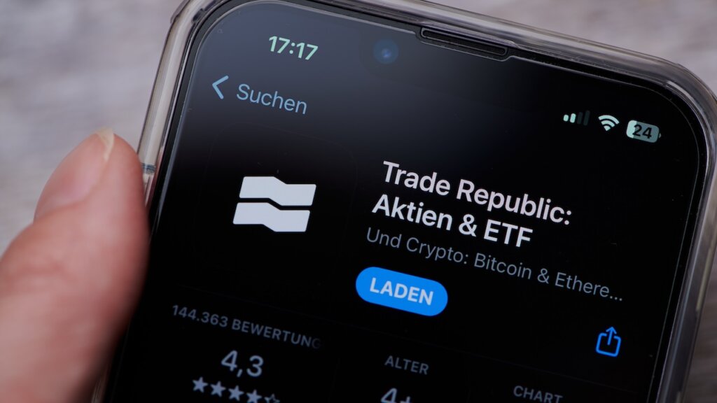 Smarthone mit der App Trade Republic und Laden-Button auf dem Bildschirm