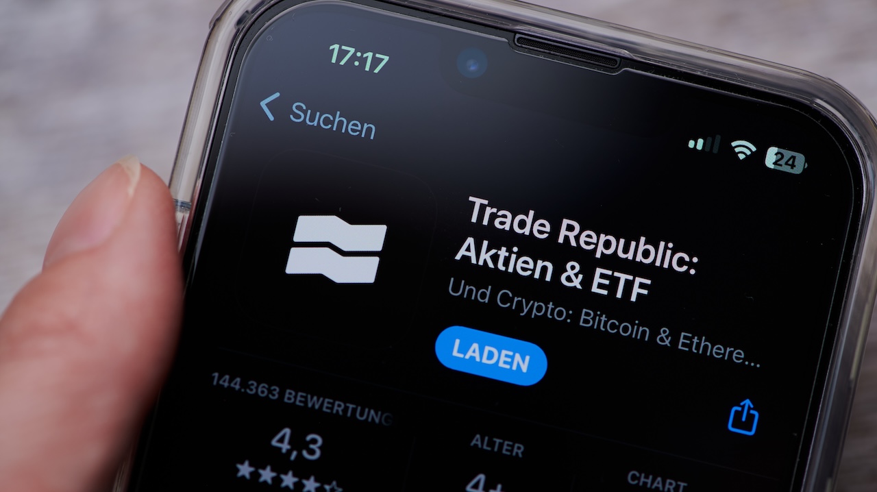 Smarthone mit der App Trade Republic und Laden-Button auf dem Bildschirm