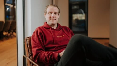Stefan Gierschke mit rotem Hoodie auf einem Sessel