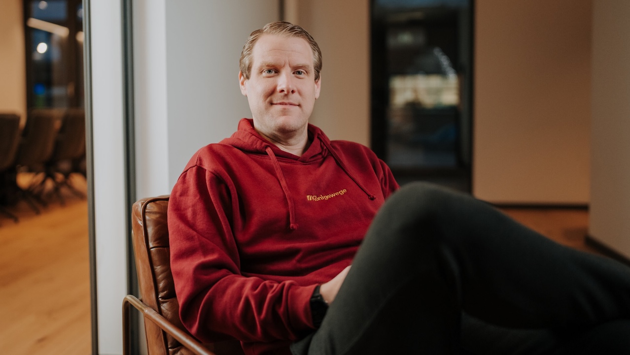 Stefan Gierschke mit rotem Hoodie auf einem Sessel