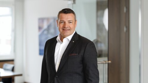 Mario Freis vor einem Büro-Hintergrund