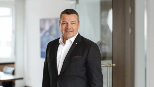 Mario Freis vor einem Büro-Hintergrund