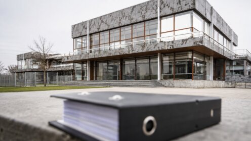 Fassade des Bundesverfassungsgerichts in Karlsruhe, im Vordergrund unscharf ein Aktenordner.